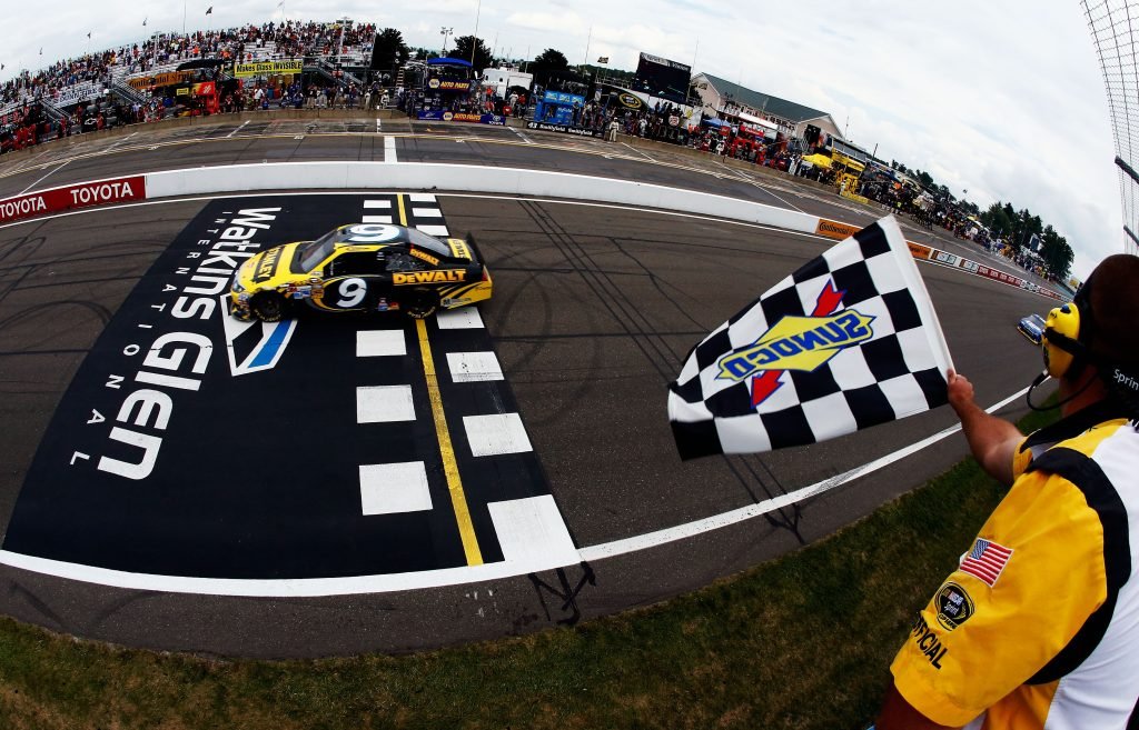 WATKINS GLEN, NY - AUGUST 12: Marcos Ambrose, driver of the #9 Stanley Ford, races past the checkered flag to win the NASCAR Sprint Cup Series Finger Lakes 355 at the Glen at Watkins Glen International on August 12, 2012 in Watkins Glen, New York. (Photo by Jared Wickerham/Getty Images)