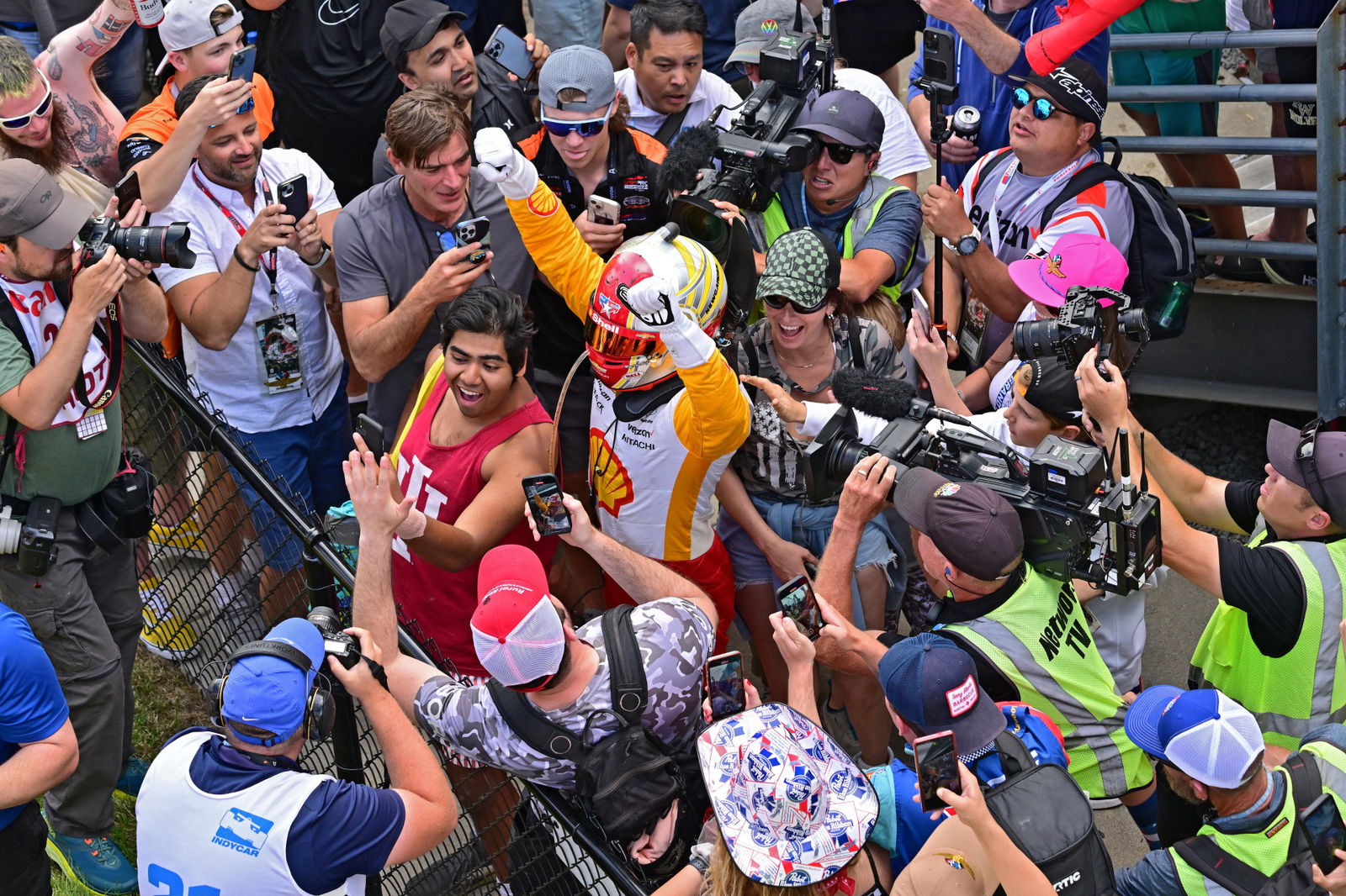 Josef Newgarden celebrates winning the Indianapolis 500 with fans. 