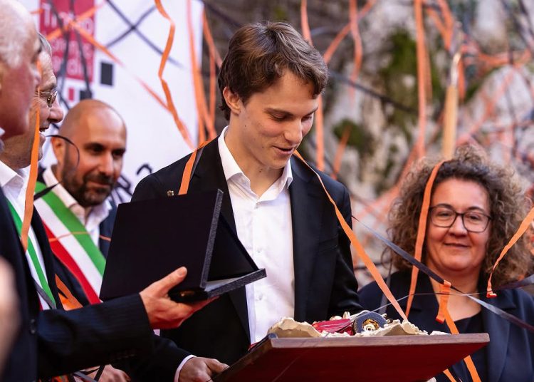 Oscar Piastri looks at the Lorenzo Bandini Trophy.