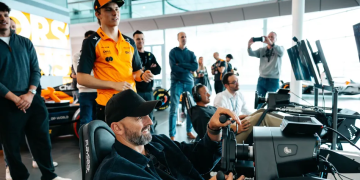 Oscar Piastri takes Nathan Lyon for a spin on the simulator at McLaren HQ. Image: Cricket Australia