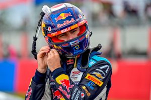 Race car driver adjusting his helmet before an event.