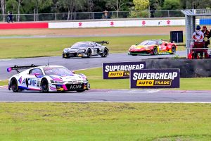 Sports cars racing around a bend on a motorsport track.