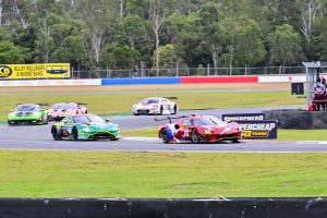 Sports cars racing around a bend on a motorsport track.