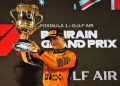 McLaren driver Oscar Piastri lifts a trophy.
