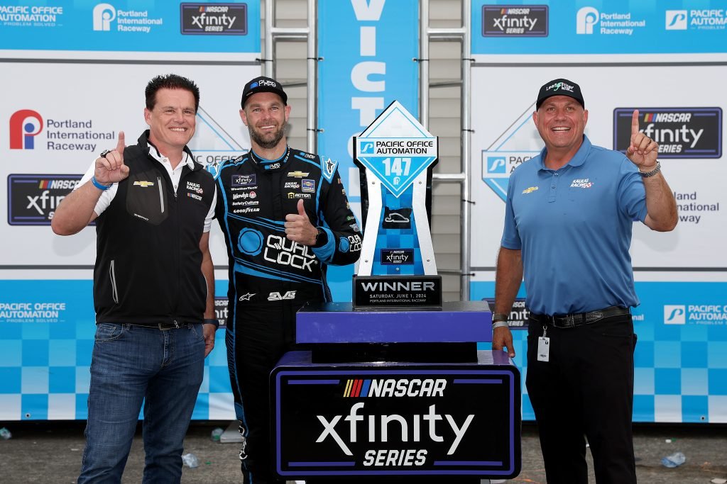 PORTLAND, OREGON - JUNE 01: (L-R) Matt Kaulig, owner of Kaulig Racing, Shane Van Gisbergen, driver of the #97 Quad Lock Chevrolet, and Chris Rice, President of Kaulig Racing celebrate in victory lane after winning the NASCAR Xfinity Series Pacific Office Automation 147 at Portland International Raceway on June 01, 2024 in Portland, Oregon. (Photo by Meg Oliphant/Getty Images)