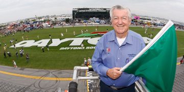 NASCAR legend Bobby Allison poses with the green flag prior to starting the NASCAR Cup Series Daytona 500 at Daytona International Speedway in 2009. Image: