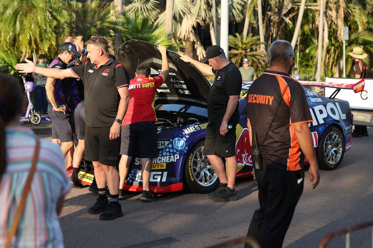 Triple Eight crew members look under the bonnet of Broc Feeney's Camaro; note also Supercars General Manager of Motorsport Tim Edwards in the foreground. Image: InSyde Media