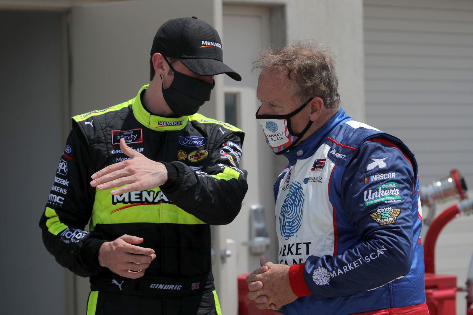 Austin Cindric (left) speaks with Mike Wallace in the garage area during practice for the NASCAR Xfinity Series Pennzoil 150 at the Brickyard at Indianapolis Motor Speedway in 2020. Image: 