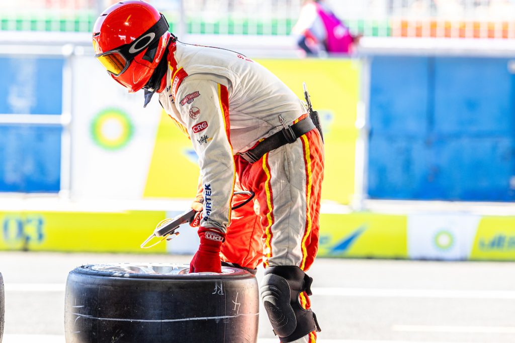 A Dick Johnson Racing crew member holding a tyre at the 2023 Bathurst 1000 at Mount Panorama