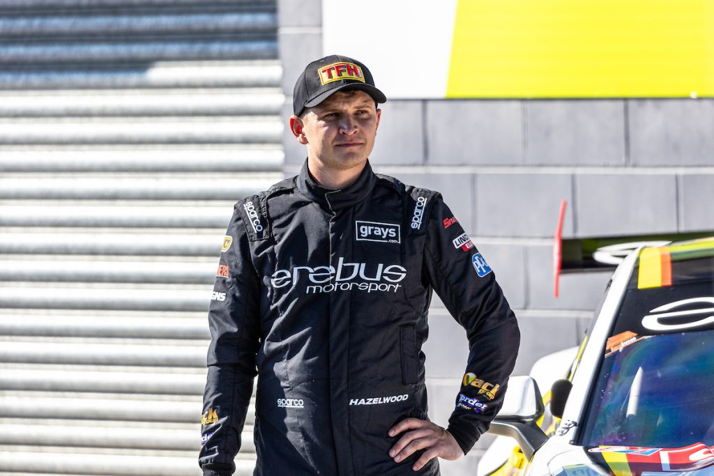 Todd Hazelwood standing next to an Erebus Motorsport Chevrolet Camaro in pit lane ahead of the Supercars Bathurst 500 at Mount Panorama in February 2024