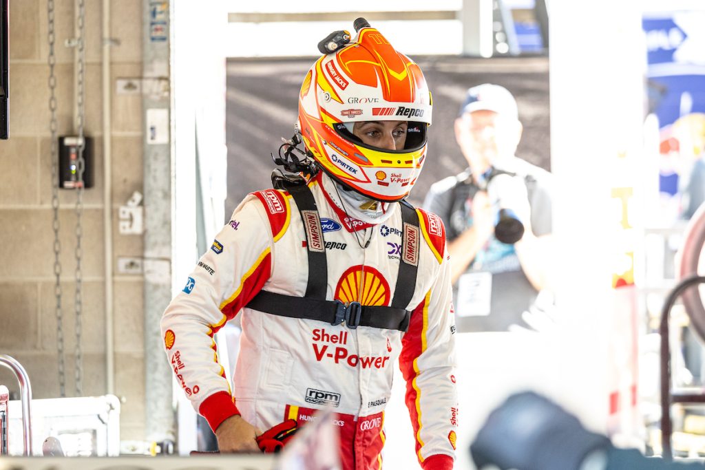 Anton De Pasquale stands in the Dick Johnson Racing garage at Townsville, wearing helmet and Simpson device