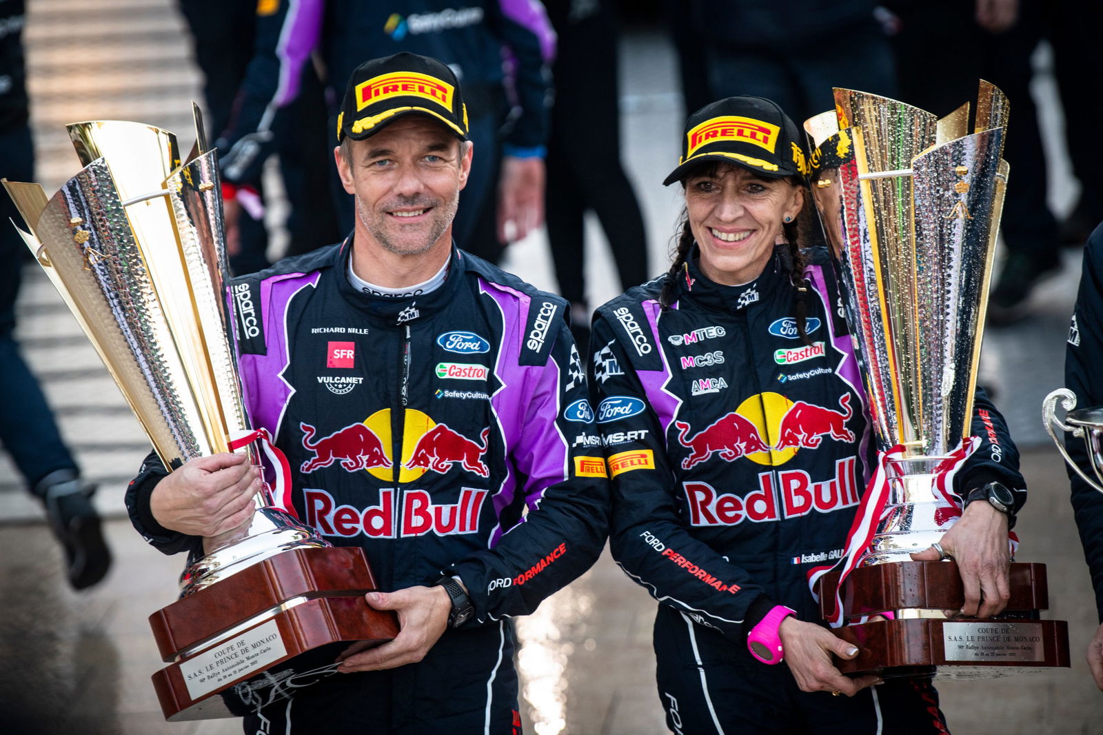 Sébastien Loeb (and Isabelle Galmiche of team M-Sport Ford World Rally Team celebrate on the podium after winning the 2022 Monte-Carlo Rally.