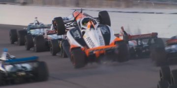 Alexander Rossi climbs over the back of Will Power on the penultimate race restart at Gateway.