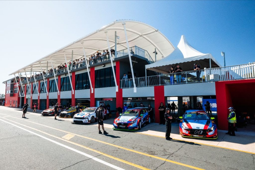 TCR cars parked in pit lane garages at Queensland Raceway in 2023