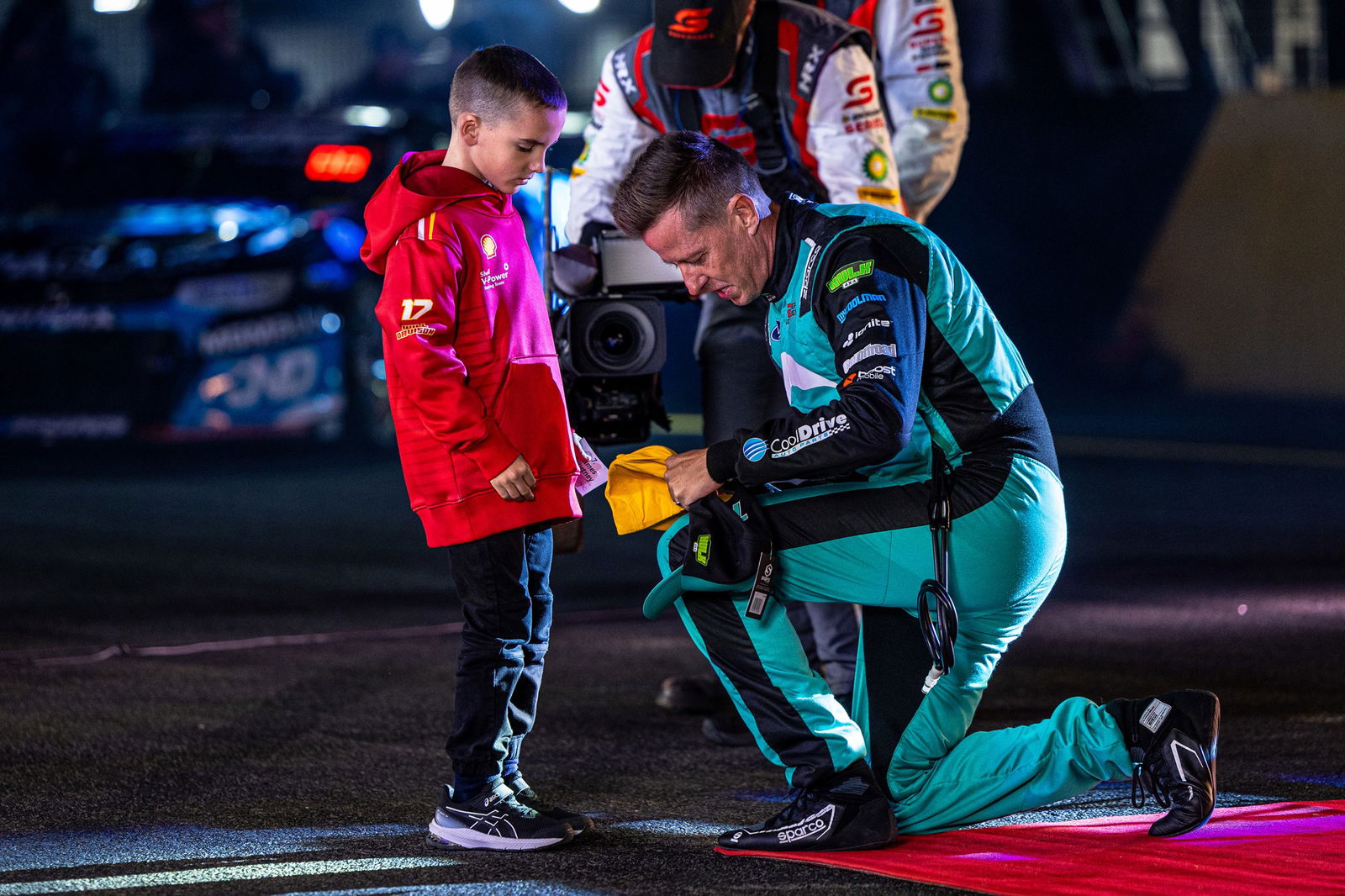 James Courtney signs a Dunlop hat for a fan during driver introductions at the Sydney SuperNight.